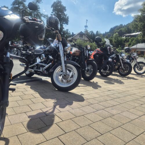 Sechs unterschiedlich gestaltete Motorräder stehen nebeneinander auf gepflastertem Boden